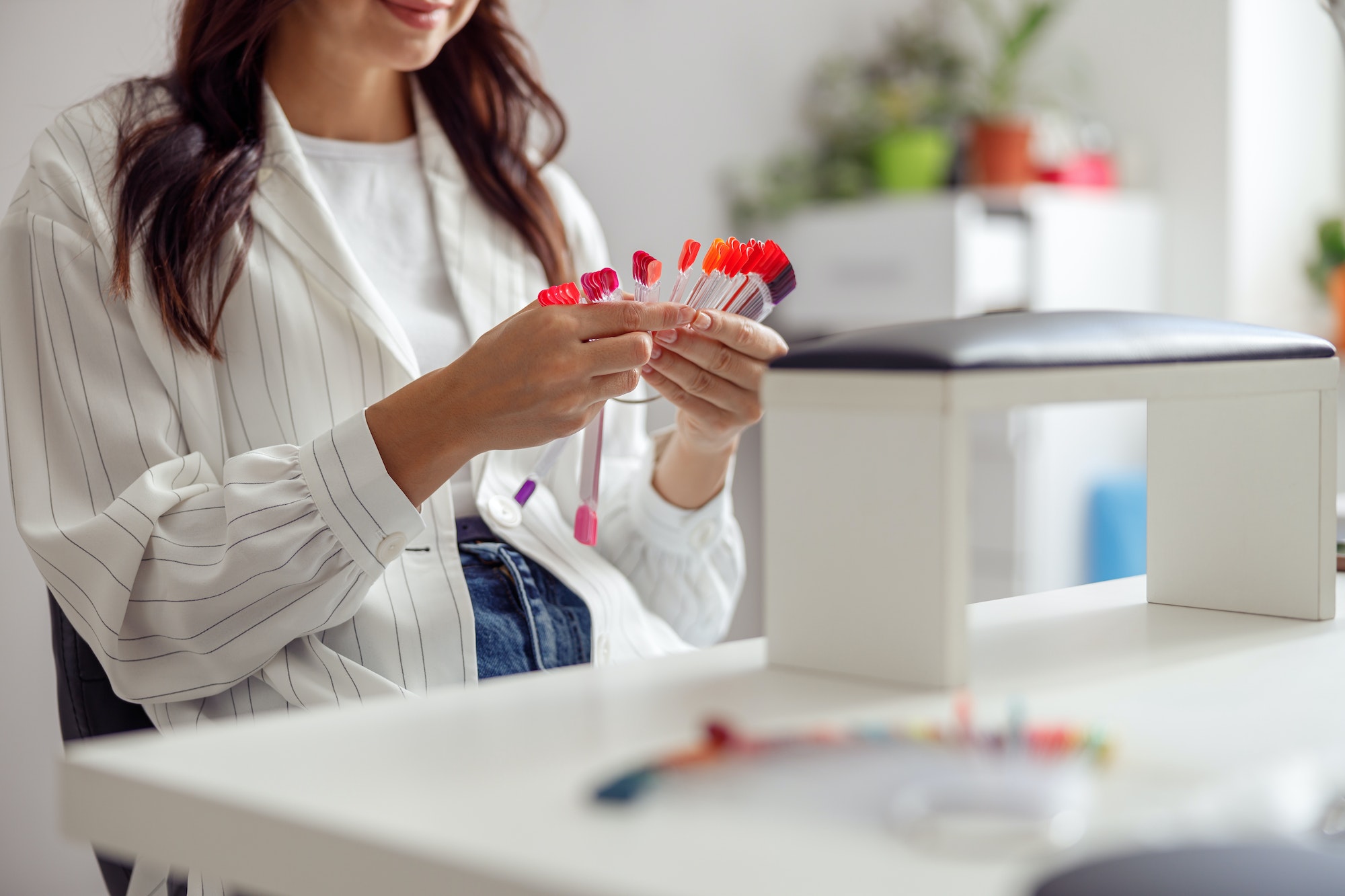 Confident woman having nail manicure in nail art studio